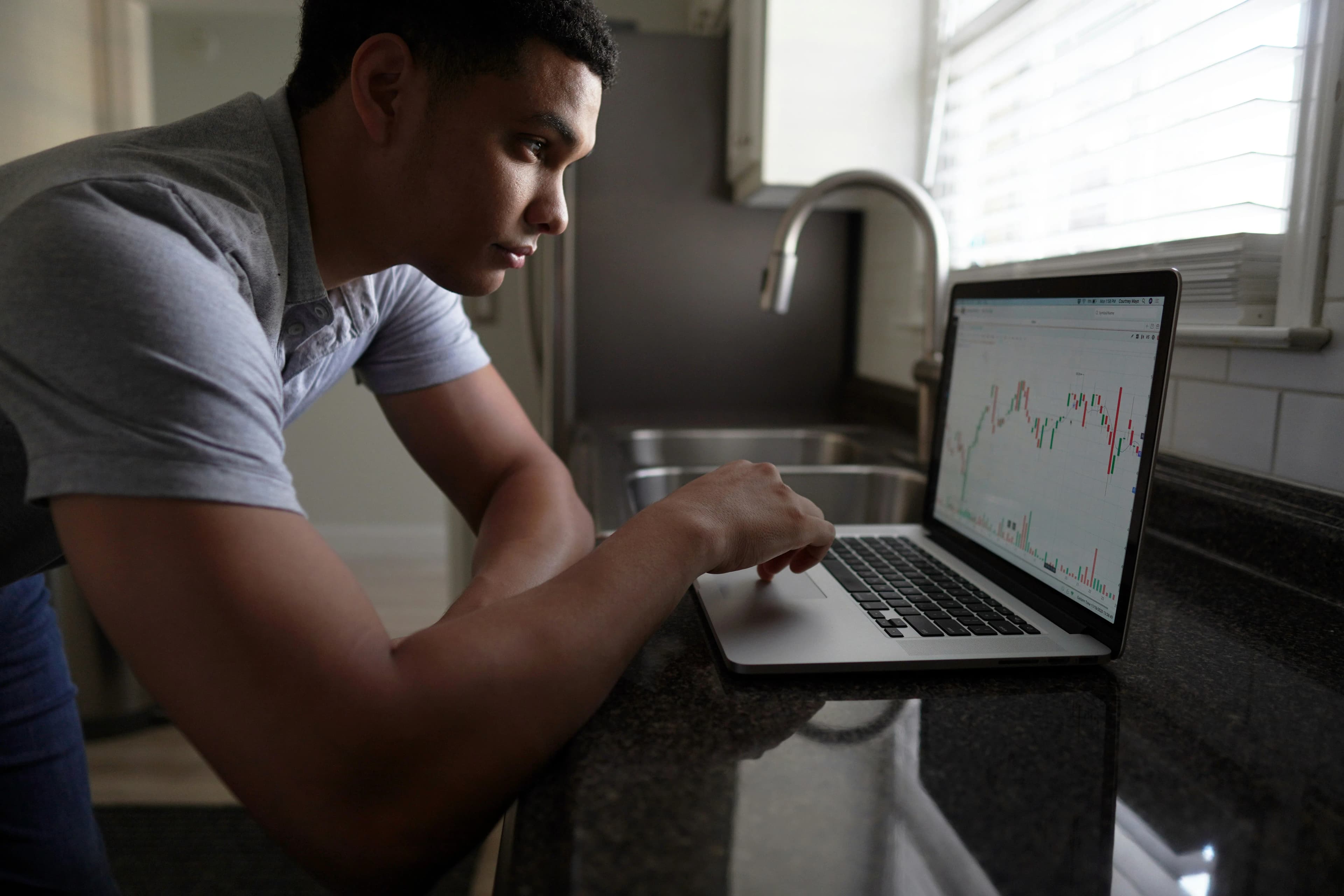 Man in gray t-shirt using a MacBook (Joshua Mayo, Unsplash)