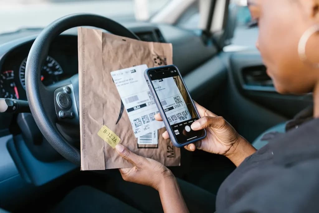 Person holding a cellphone and parcel
