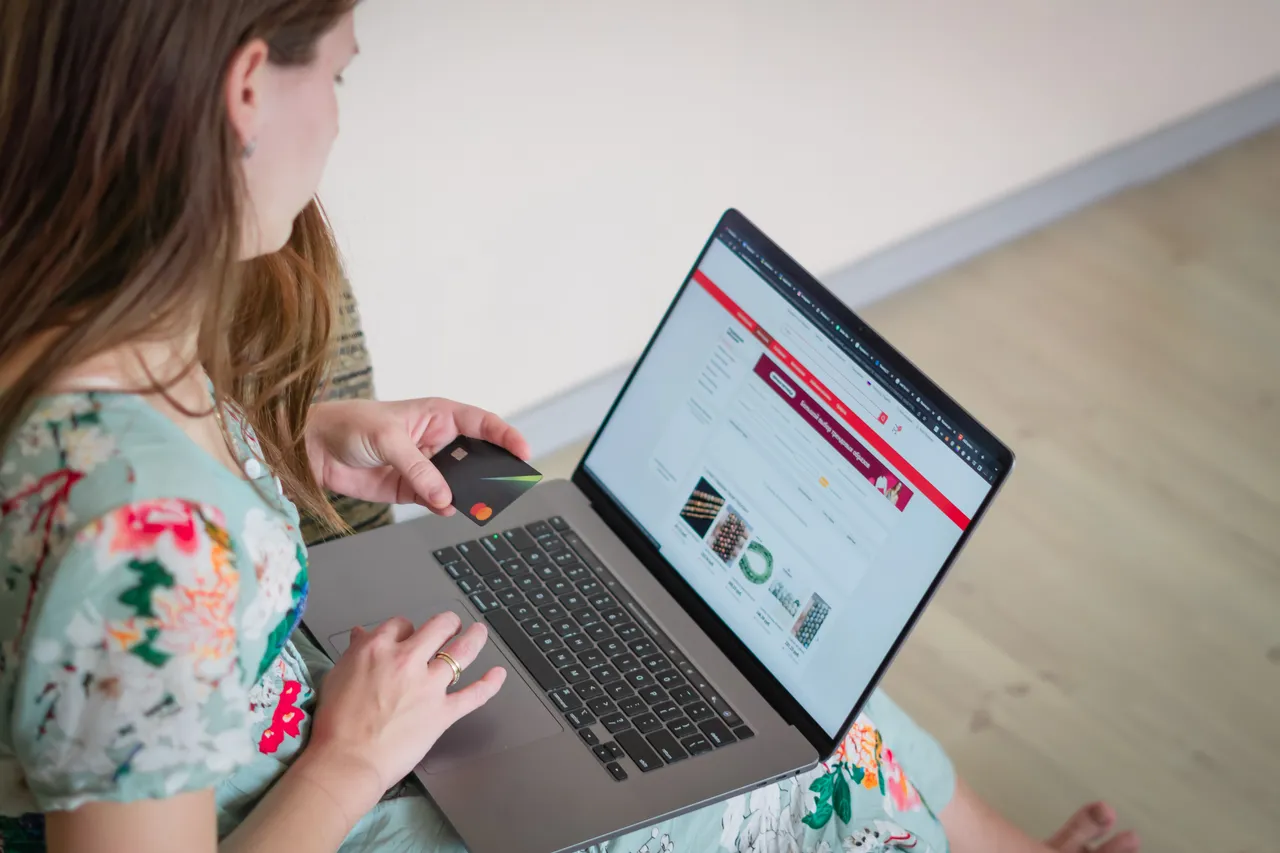 A woman shopping online with a laptop and credit card