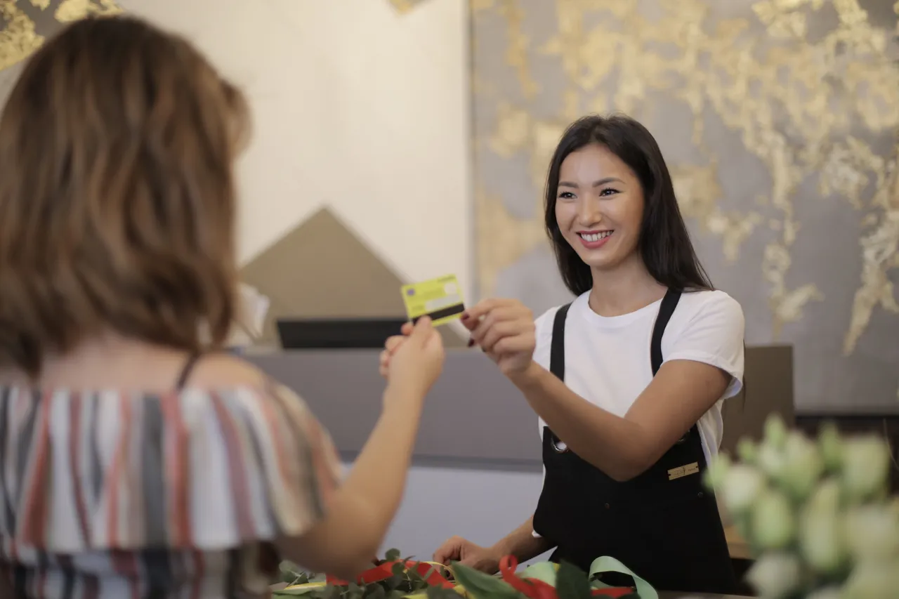 A woman paying with a credit card at a retail counter