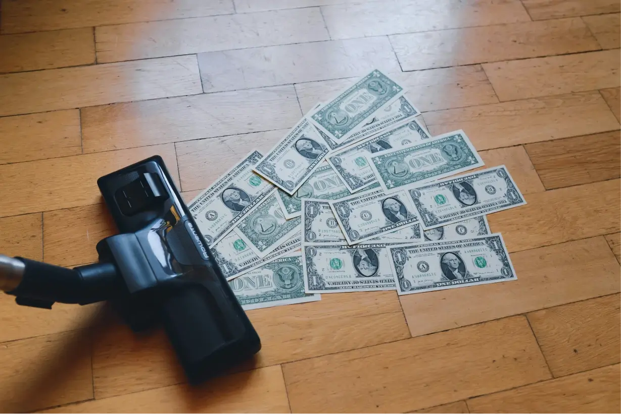 a pile of money absorbed by a vacuum cleaner